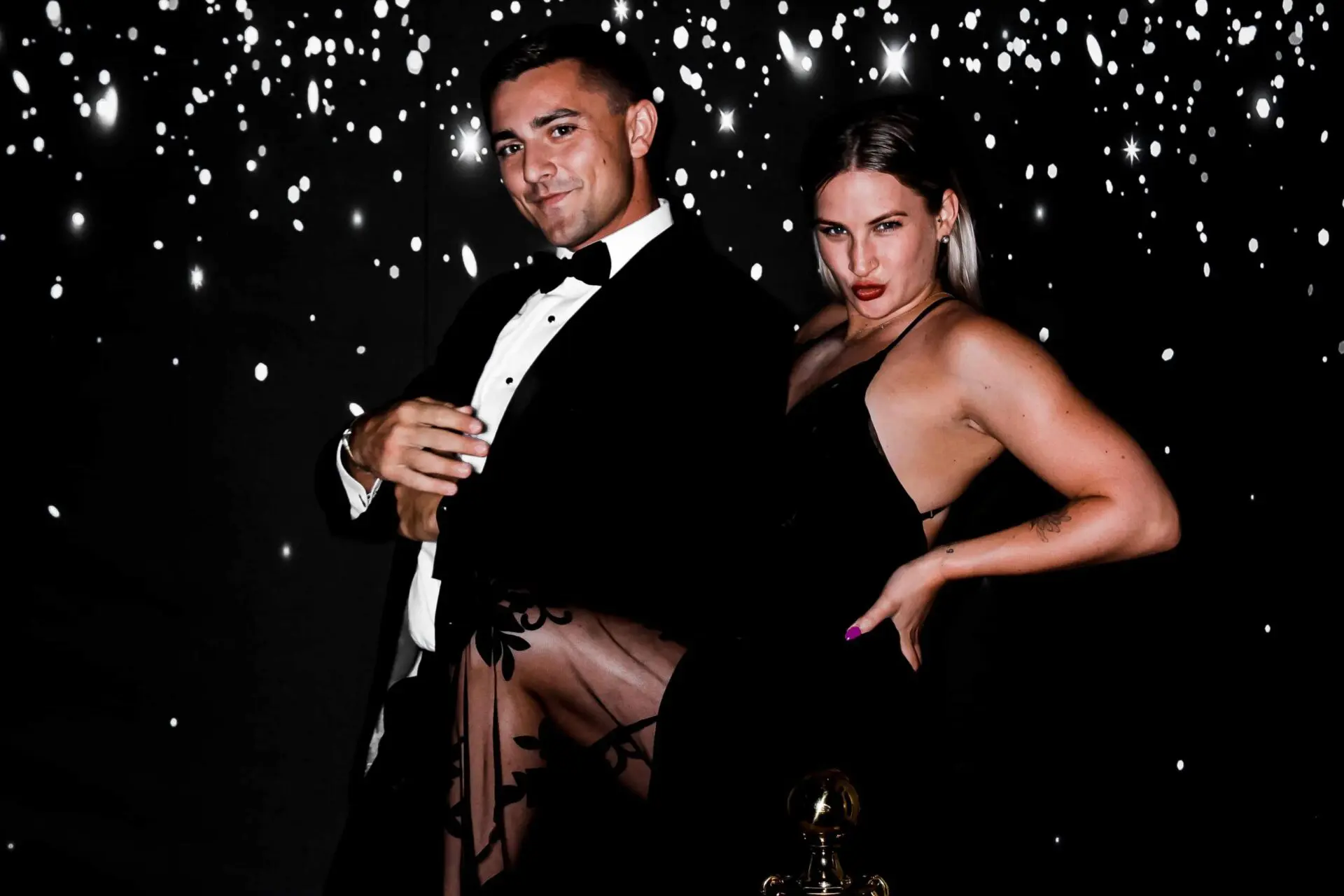 Couple posing for a picture in front of a photobooth at a wedding in Charlotte North Carolina.