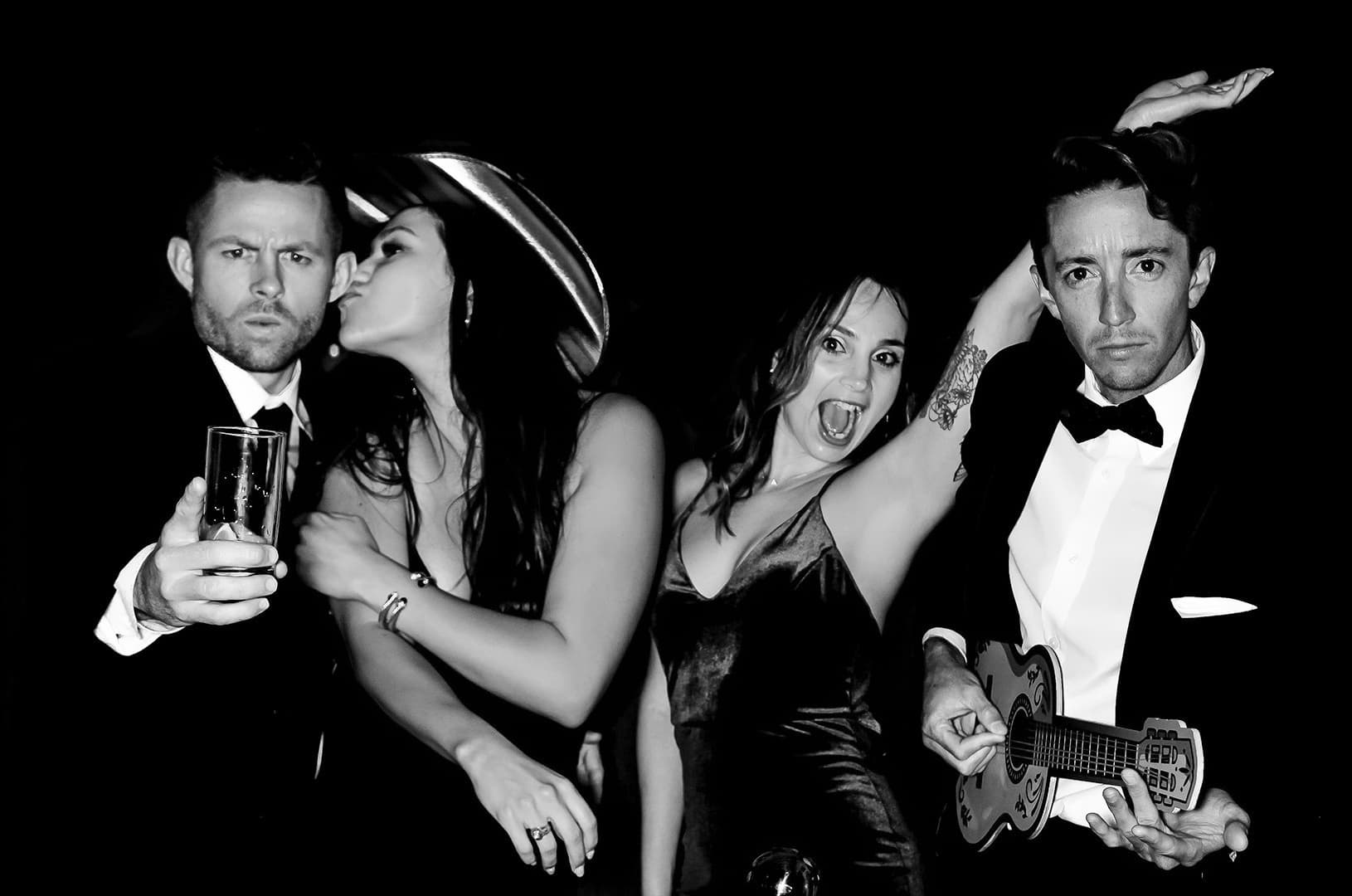 a group of people posing for a picture in front of a photobooth at a wedding in Charlotte North Carolina.